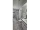 Bright bathroom featuring a glass enclosed shower, white vanity, and tiled floors at 4500 Onorio St, New Port Richey, FL 34653