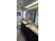 Bathroom with double sink vanity with dark cabinets and large mirror at 4500 Onorio St, New Port Richey, FL 34653