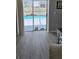 Living room with gray toned wood flooring and view to screened in lanai and pool at 4500 Onorio St, New Port Richey, FL 34653