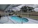 Enclosed pool area with a rock waterfall feature, table, chairs, and relaxing atmosphere at 4500 Onorio St, New Port Richey, FL 34653