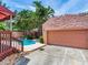A private backyard features a pool, covered patio, lush tropical landscaping, and two car garage at 4521 W Azeele St, Tampa, FL 33609