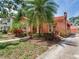Landscaped front exterior with peach stucco home, featuring a red tiled roof and mature landscaping at 4521 W Azeele St, Tampa, FL 33609