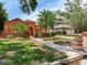 Charming peach stucco home featuring a red tiled roof, mature trees and a paved walkway to the home at 4521 W Azeele St, Tampa, FL 33609