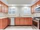 Bright kitchen with stainless steel appliances, wood cabinets, granite counters, and tile floors at 4521 W Azeele St, Tampa, FL 33609