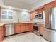 Bright kitchen featuring stainless steel appliances, wood cabinets, a window, and tile floors at 4521 W Azeele St, Tampa, FL 33609