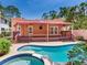 Backyard pool and deck with a covered patio and lush tropical landscaping at 4521 W Azeele St, Tampa, FL 33609
