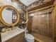 Elegant bathroom with intricate wallpaper, a gold-framed mirror, and a glass-enclosed shower at 4611 Ackerly Way, Brandon, FL 33511