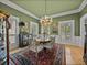 Elegant dining room featuring a chandelier, area rug, and natural light from the shuttered windows at 4611 Ackerly Way, Brandon, FL 33511