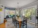 Sunlit dining room with a bay window, chandelier lighting, and seating for six at 4611 Ackerly Way, Brandon, FL 33511