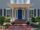 Inviting entryway with a bright blue door, brick steps, and manicured landscaping at 4611 Ackerly Way, Brandon, FL 33511