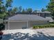 Attached two-car garage with grey door, exterior lighting, and spacious driveway at 4611 Ackerly Way, Brandon, FL 33511