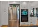 Bright kitchen featuring a stainless steel refrigerator, black oven, and gray cabinets at 4611 Ackerly Way, Brandon, FL 33511