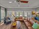 Bright living room featuring a ceiling fan, a leather sofa, and ample natural light at 4611 Ackerly Way, Brandon, FL 33511