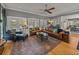 Open living room with hardwood floors, a leather sectional, and doors leading to outdoor pool at 4611 Ackerly Way, Brandon, FL 33511