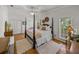 Bright main bedroom featuring a four-poster bed, wood floors, and natural light at 4611 Ackerly Way, Brandon, FL 33511