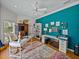 Sunlit home office featuring a blue accent wall, ceiling fan and hardwood floors at 4611 Ackerly Way, Brandon, FL 33511