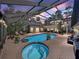 Enclosed pool area with a hot tub, pool, outdoor seating, and string lights for an evening of relaxation at 4611 Ackerly Way, Brandon, FL 33511