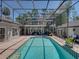 Enclosed pool area with a pool, outdoor seating, spiral staircase, and a second-story balcony perfect for relaxation at 4611 Ackerly Way, Brandon, FL 33511