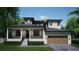 New construction featuring a covered porch and front-facing garage and well-maintained landscaping at 4612 W Tennyson Ave, Tampa, FL 33629