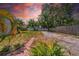 A spacious backyard with a brick path, lush greenery, and a mix of grass and gravel areas at 4684 72 N Ave, Pinellas Park, FL 33781