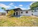 Exterior view of home with a fenced backyard featuring a covered patio and partial lawn at 4684 72 N Ave, Pinellas Park, FL 33781