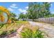 A spacious backyard with a brick path, lush greenery, and a mix of grass and gravel areas at 4684 72 N Ave, Pinellas Park, FL 33781