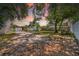 This backyard view shows the home with a shed and mature trees under a pink-hued sunset at 4684 72 N Ave, Pinellas Park, FL 33781