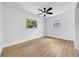 Bright bedroom features wood floors, a ceiling fan, and two windows at 4684 72 N Ave, Pinellas Park, FL 33781