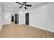 Spacious bedroom with wood-look floors, ceiling fan, neutral walls, and black doors at 4684 72 N Ave, Pinellas Park, FL 33781