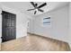 Bedroom featuring light wood floors, closet, fan, and black painted doors at 4684 72 N Ave, Pinellas Park, FL 33781