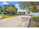 Wide shot of the house with a new gravel driveway, attractive landscaping and freshly painted exterior at 4684 72 N Ave, Pinellas Park, FL 33781
