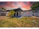 Exterior view of home with covered patio, palm trees, and landscaping at 4684 72 N Ave, Pinellas Park, FL 33781