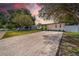 Wide shot of the house with a new gravel driveway, attractive landscaping and freshly painted exterior at 4684 72 N Ave, Pinellas Park, FL 33781