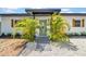 The front entrance shows a black trimmed awning, decorative shutters, and is framed by lovely palm trees at 4684 72 N Ave, Pinellas Park, FL 33781