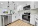 Modern kitchen with white cabinets, stainless steel appliances, and a view to the home's entrance at 4684 72 N Ave, Pinellas Park, FL 33781