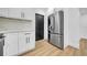 Modern kitchen with stainless steel refrigerator, white cabinets, and wood-look floors at 4684 72 N Ave, Pinellas Park, FL 33781
