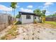 This exterior view shows a side yard, shed and home with lush greenery under a blue sky at 4684 72 N Ave, Pinellas Park, FL 33781