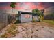 This exterior view shows a side yard, shed and home with an amazing sunset backdrop at 4684 72 N Ave, Pinellas Park, FL 33781