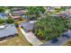 Aerial view of a residence featuring a carport, a long driveway, solar panels, and mature trees in a landscaped yard at 4915 Chariton Ave, Tampa, FL 33603