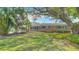 A classic brick home featuring a lush green lawn, mature trees, and green shutters, blending timeless appeal with charm at 4915 Chariton Ave, Tampa, FL 33603