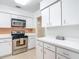Bright kitchen with white cabinets, stainless steel range, and view of extra storage in hallway at 4915 Chariton Ave, Tampa, FL 33603