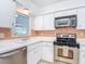 Classic white kitchen with stainless steel appliances and a window overlooking the backyard at 4915 Chariton Ave, Tampa, FL 33603