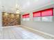 Living room featuring tile floors, ceiling fan, brick accent wall, and windows with red blinds at 4915 Chariton Ave, Tampa, FL 33603