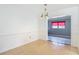 Cozy living room with terrazzo floors leading into tiled room with window and red shade at 4915 Chariton Ave, Tampa, FL 33603