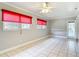 Neutral living room featuring tile floors, ceiling fan, and windows with red blinds at 4915 Chariton Ave, Tampa, FL 33603