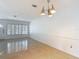 Bright living room with terrazzo floors, white walls and trim, plantation shutters, and stylish mid-century modern lighting at 4915 Chariton Ave, Tampa, FL 33603