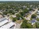 Aerial view showcasing a residential area with tree-lined streets, various homes, and a mix of commercial buildings at 5106 15Th S Ave, Gulfport, FL 33707