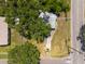 An aerial view of a house surrounded by mature trees and a yard with a driveway and nearby road at 5106 15Th S Ave, Gulfport, FL 33707