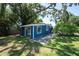 A blue home featuring a side entrance with mature trees providing shade at 5106 15Th S Ave, Gulfport, FL 33707