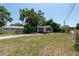 Well-kept blue cottage with a spacious front yard and mature trees, offering curb appeal at 5106 15Th S Ave, Gulfport, FL 33707